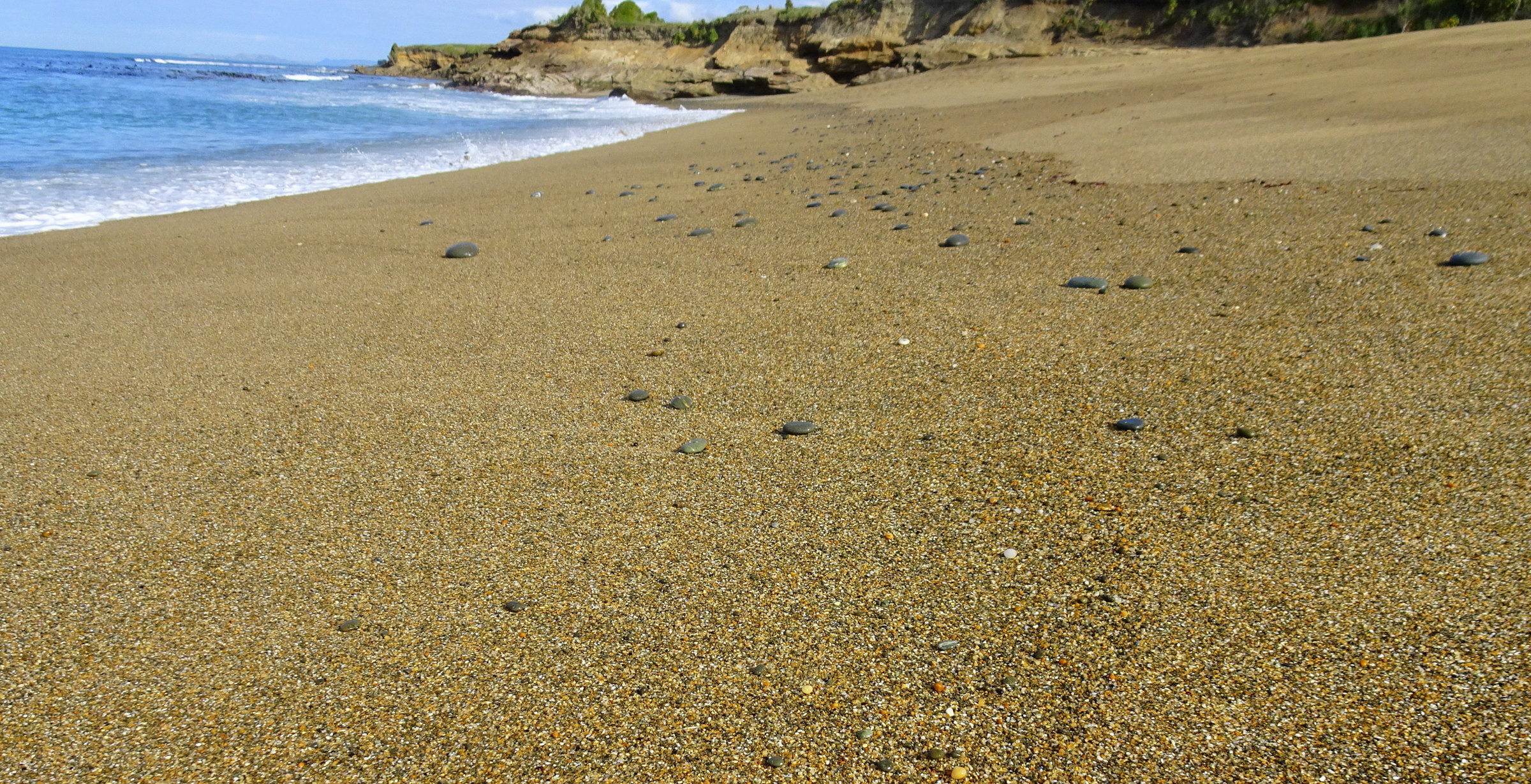 A few stones scattered along the beach as I walk to the rocks in the south.