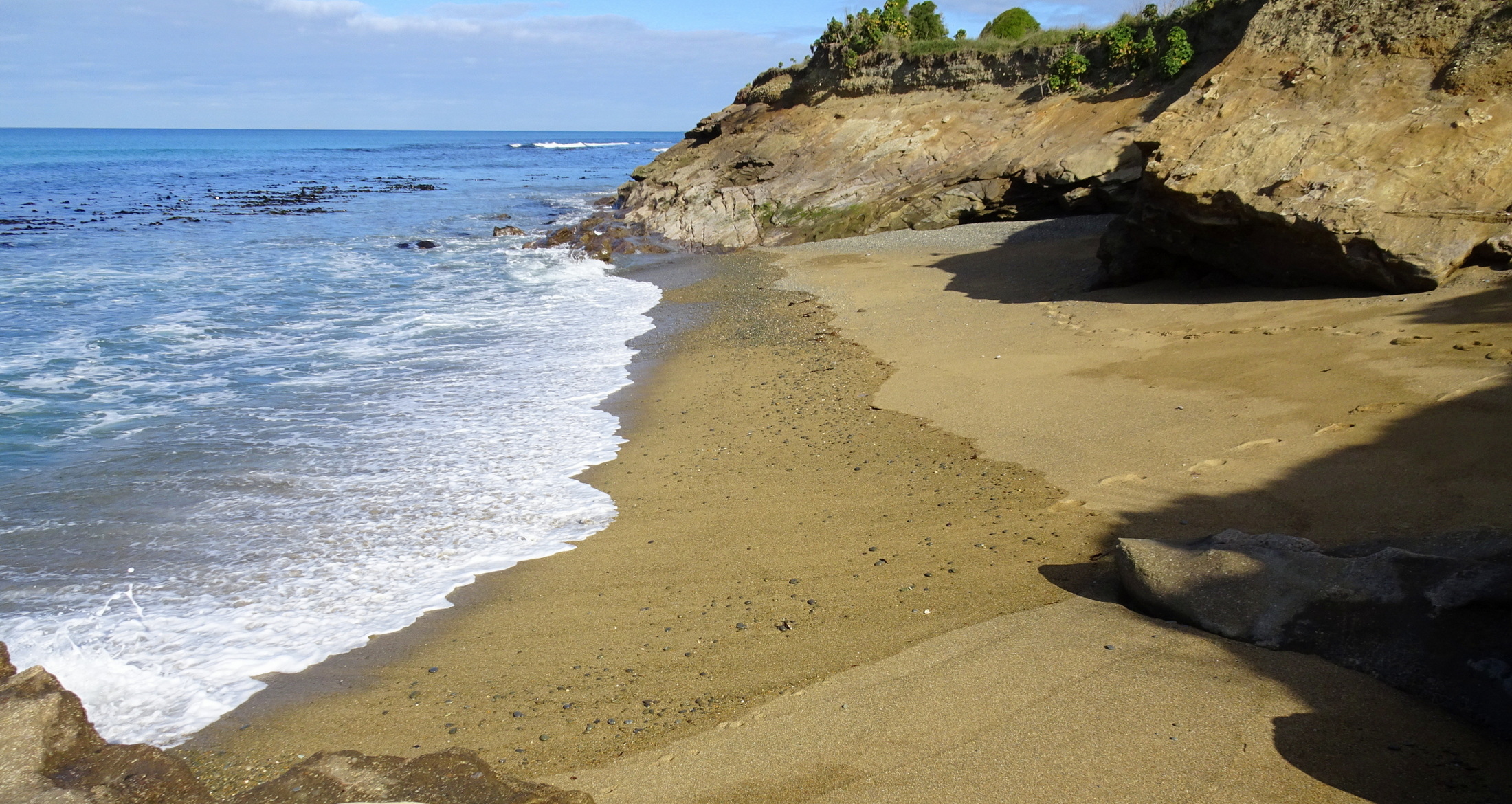 The small bay on the other side of the rocks.