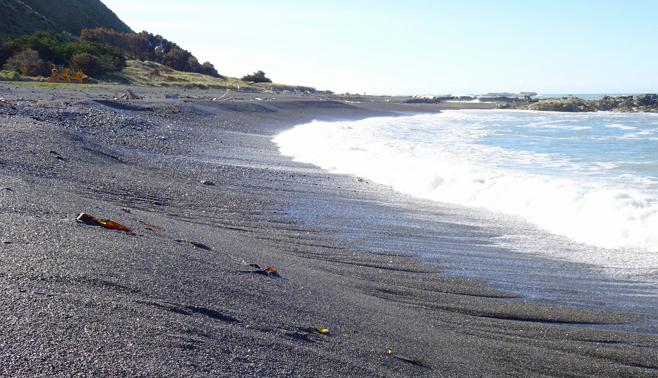 The sea has eaten into the stone beach, leaving a steep drop in places. Looking north.