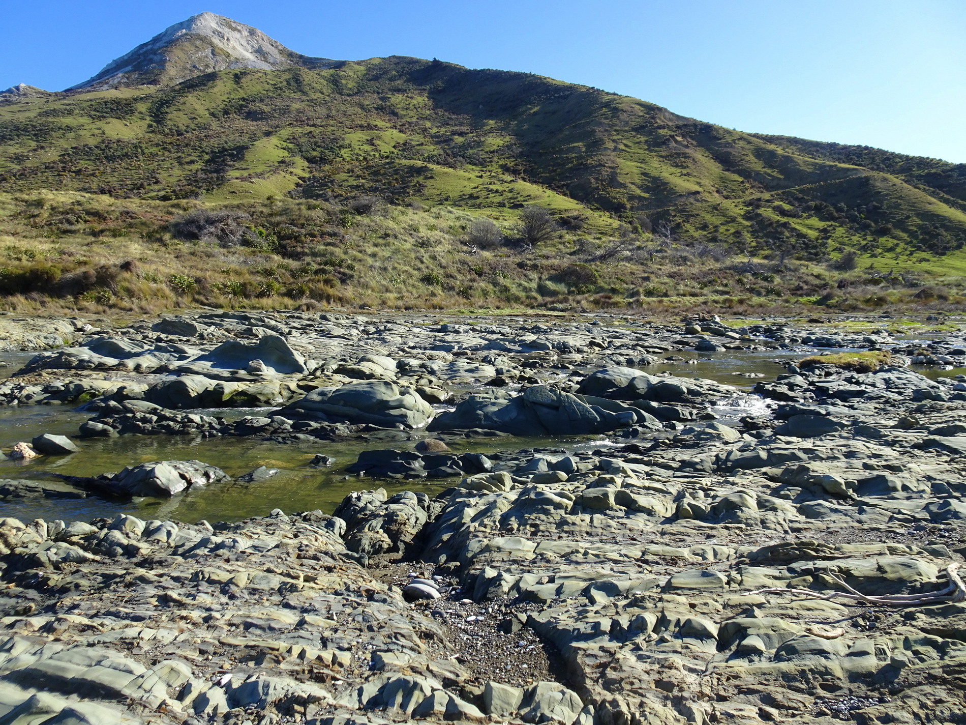 Uplifted bedrock a couple of hundred metres upstream from the river mouth. Weld Cone in background.