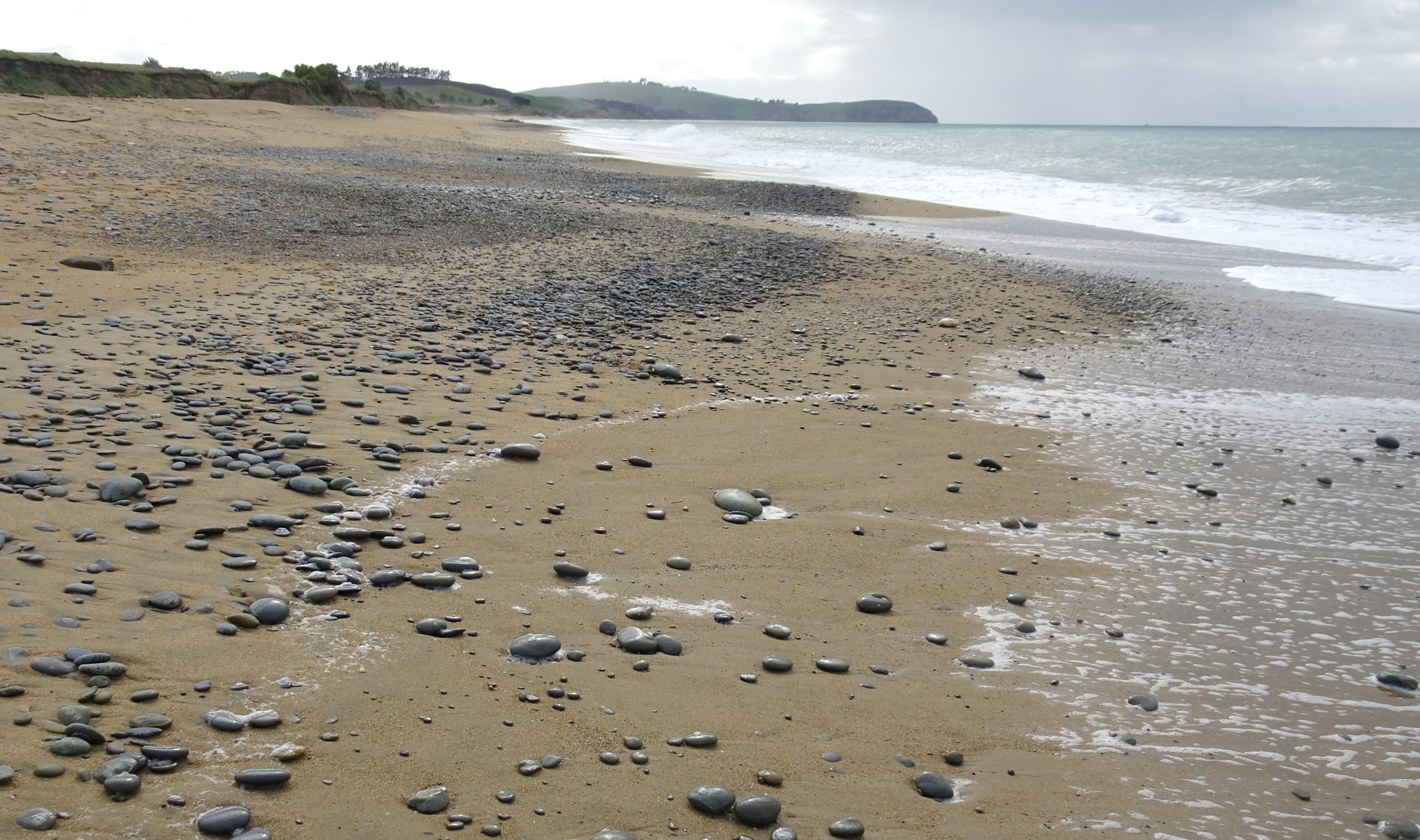 Patches of stones north along the beach.
