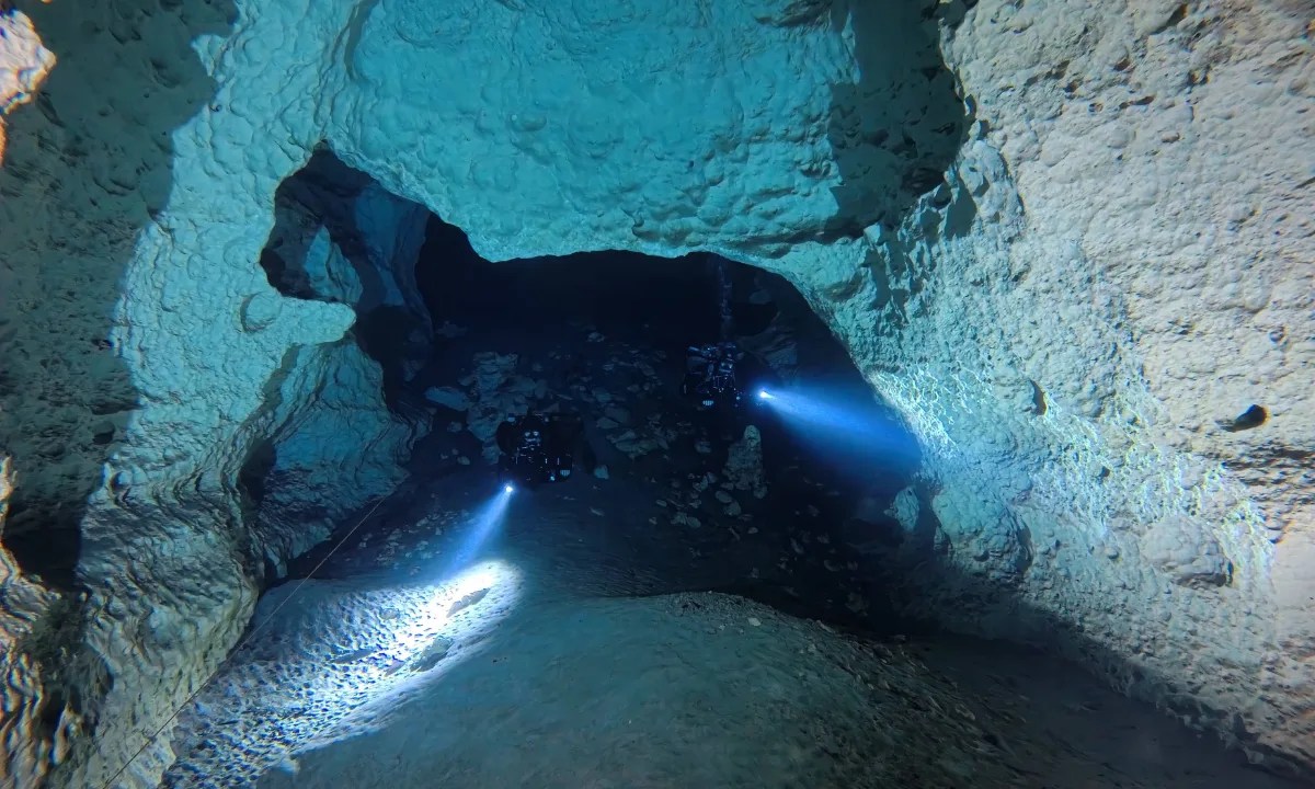 Cave divers with lights inside Peacock Springs cave system, North Florida