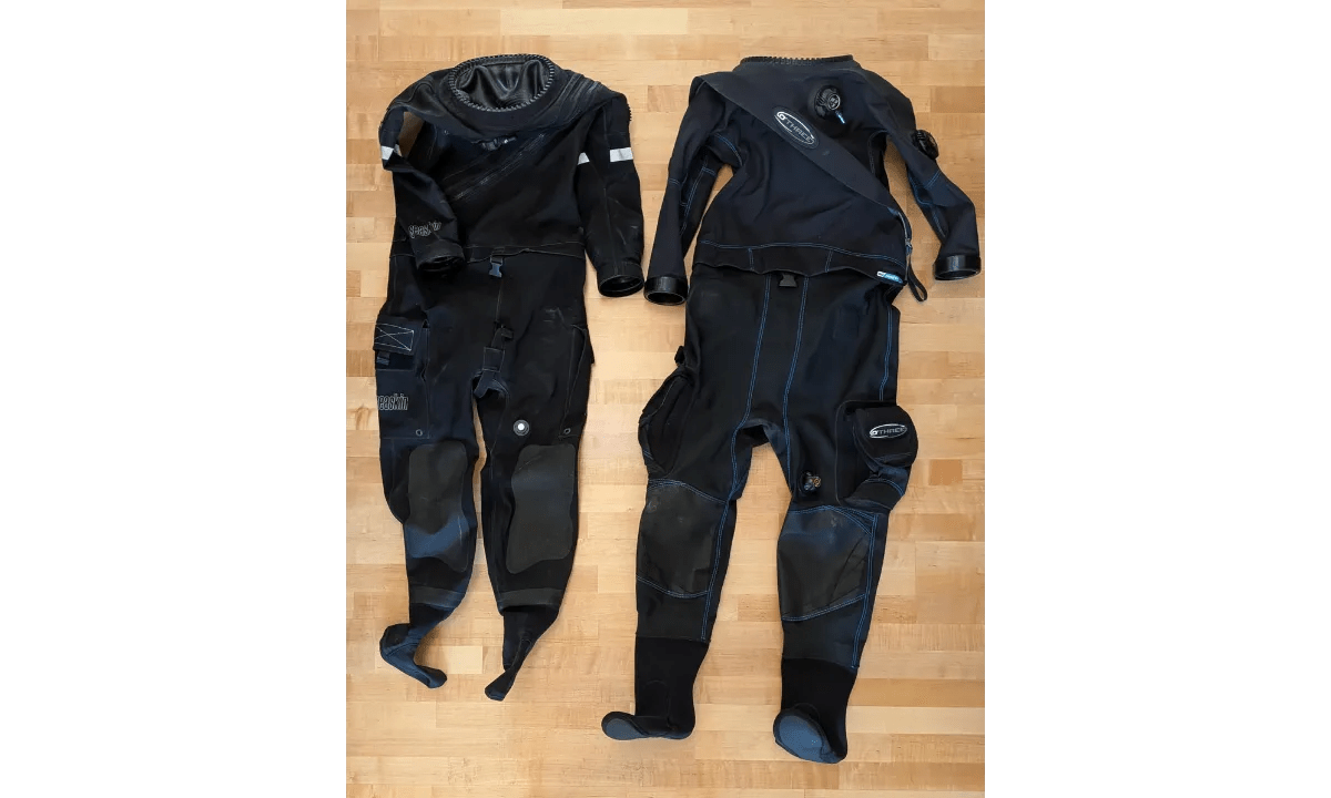 Seaskin Nova and O'Three 90Ninety Hybrid drysuits laid flat side by side on wood floor