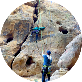 Climber and belayer at a sandstone crag
