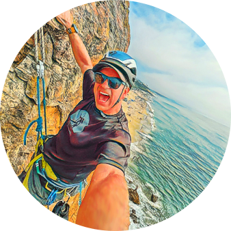 Paul Reid taking a selfie on a sea cliff above the ocean