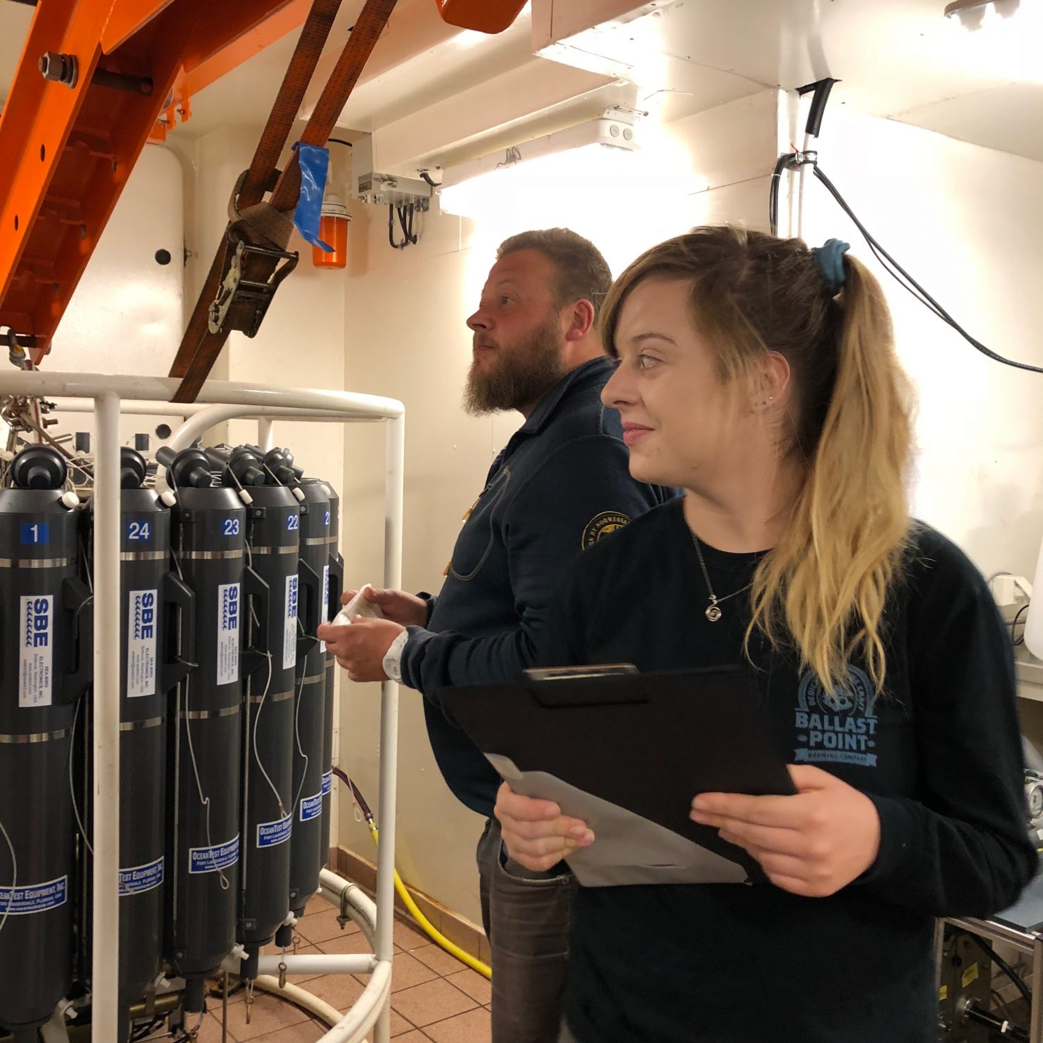 Mats Granskog and Channing Bolt look at scientific equipment.