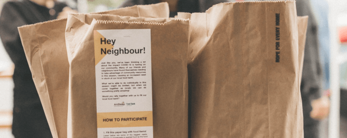 HeyNeighbour Photo of brown paper bags with "Hey Neighbour!" and an explanation of the service printed on them