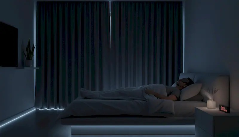 Man in his 40s sleeping peacefully in dark bedroom demonstrating sleep optimization techniques for better recovery and physical performance