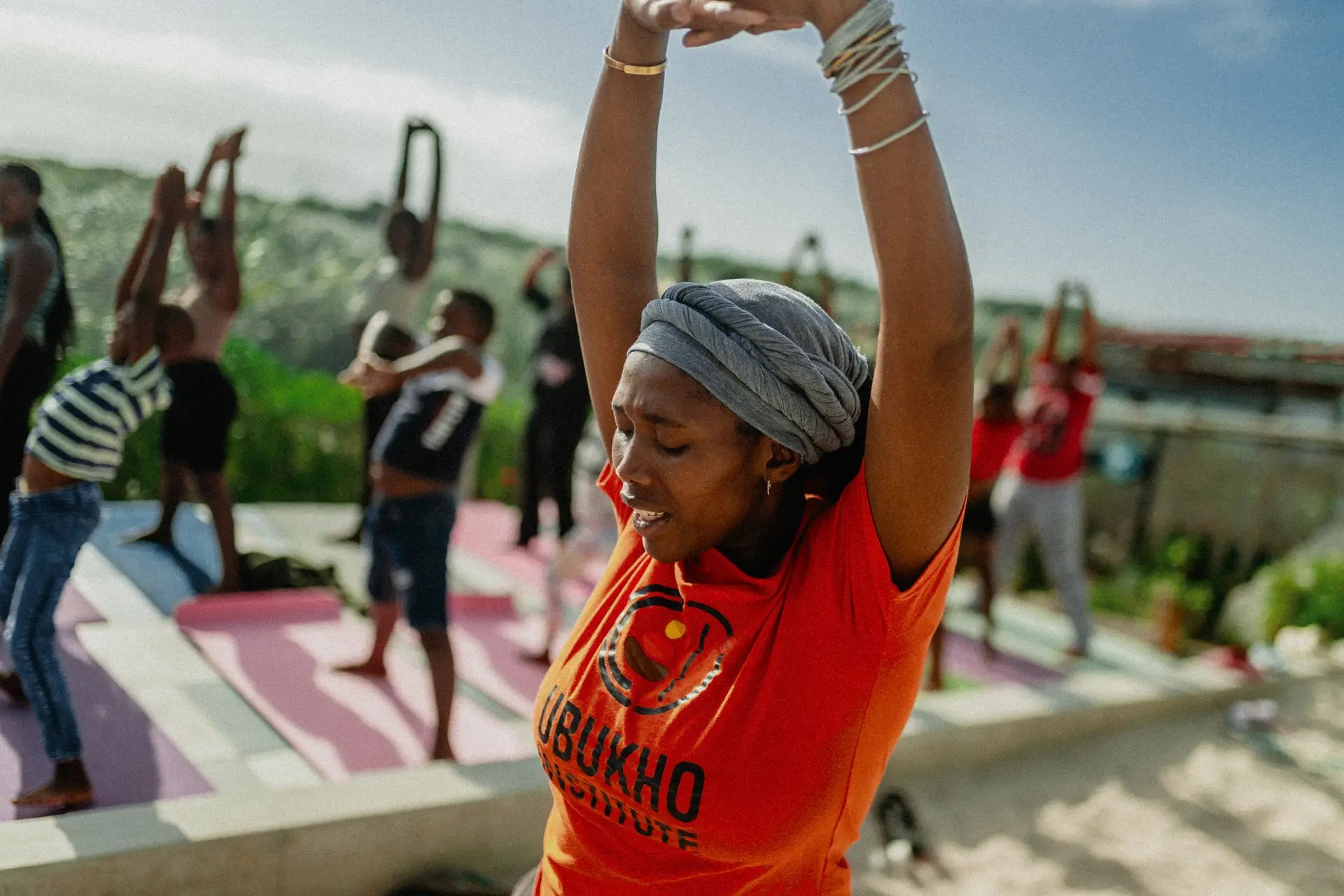 Bongeka geeft een yogales bij Thembisa Ratanga, met deelnemers op de achtergrond