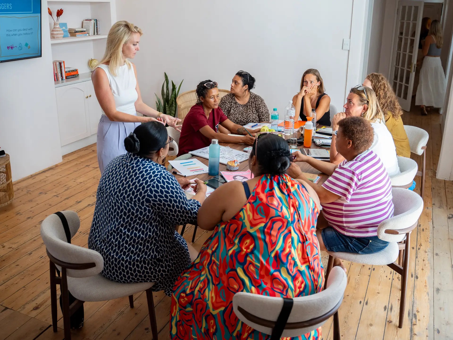 Trainer and participants seated around a table during a training, seen from above