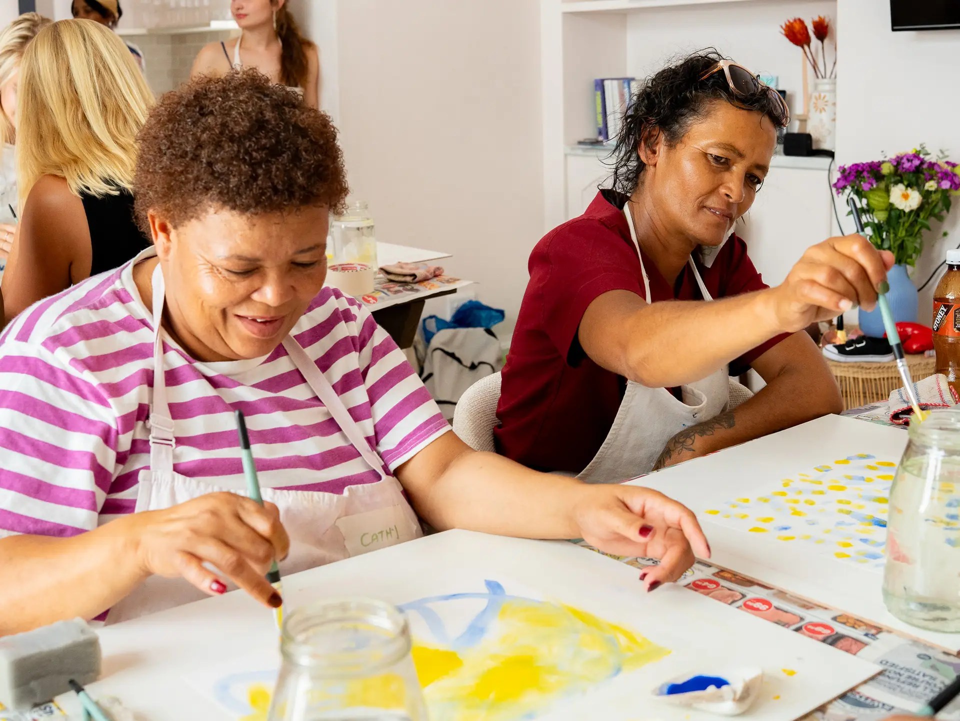 Two participants painting together during a creative training exercise