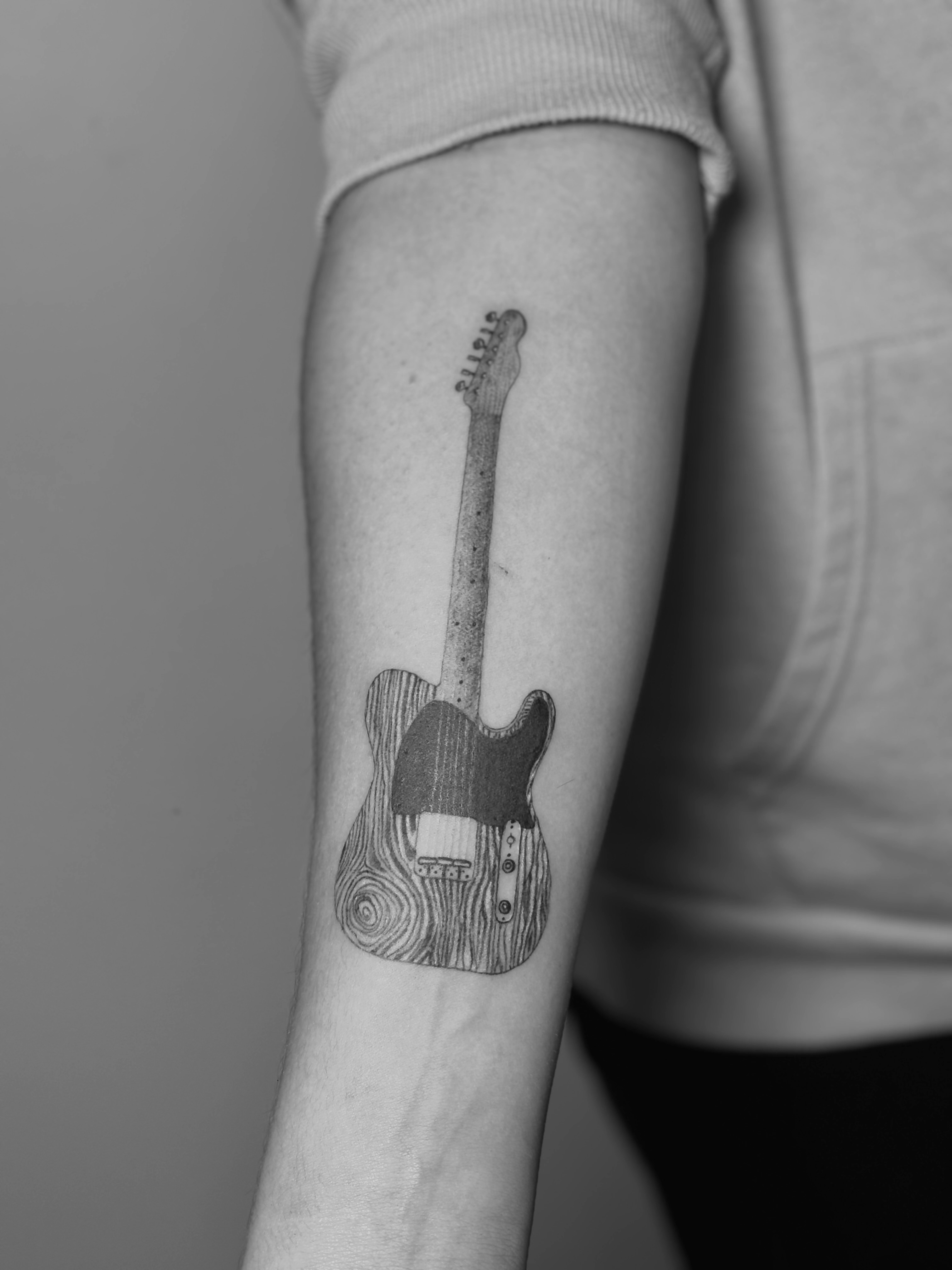Electric guitar tattoo on arm