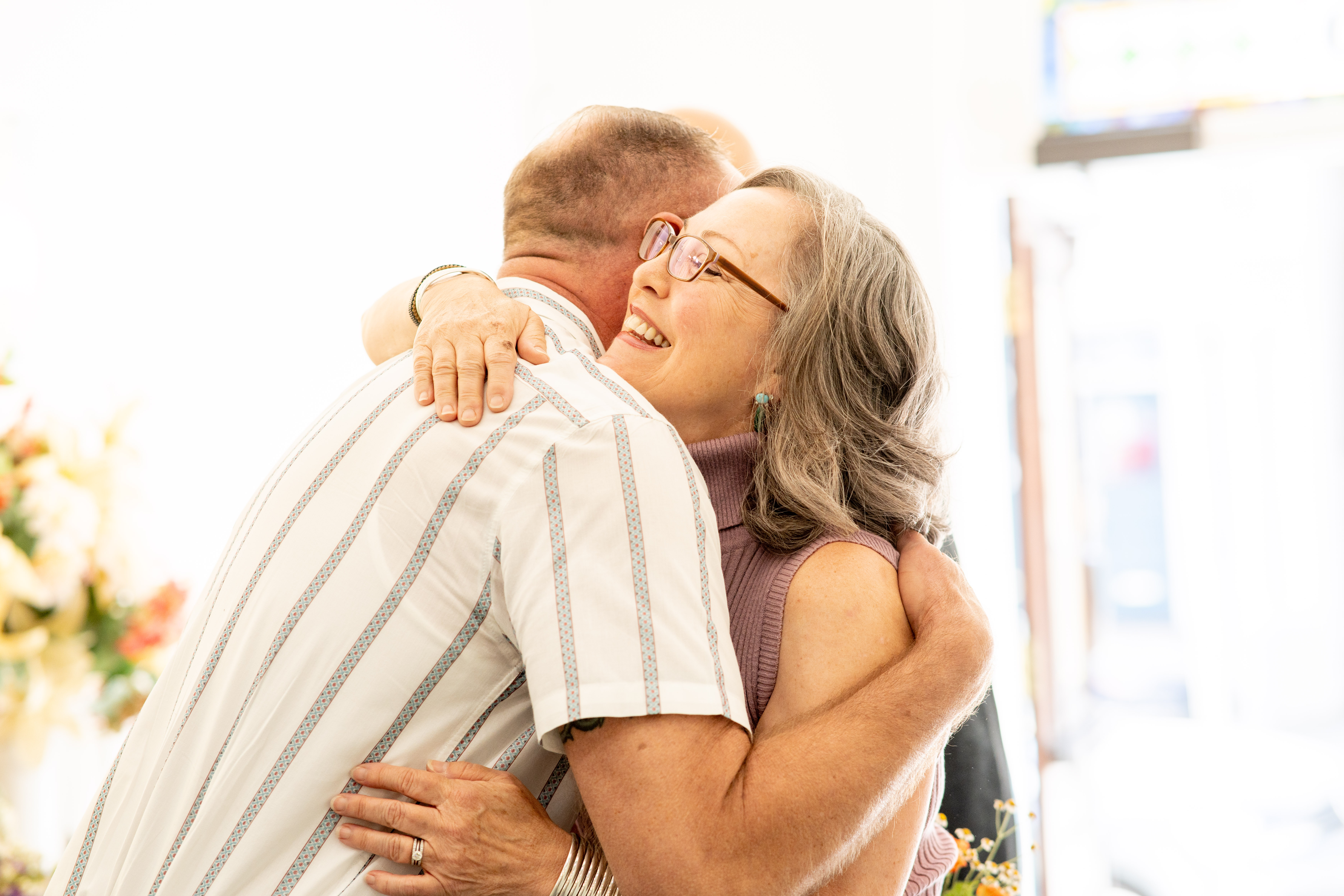 Male and female community members embracing in smile.