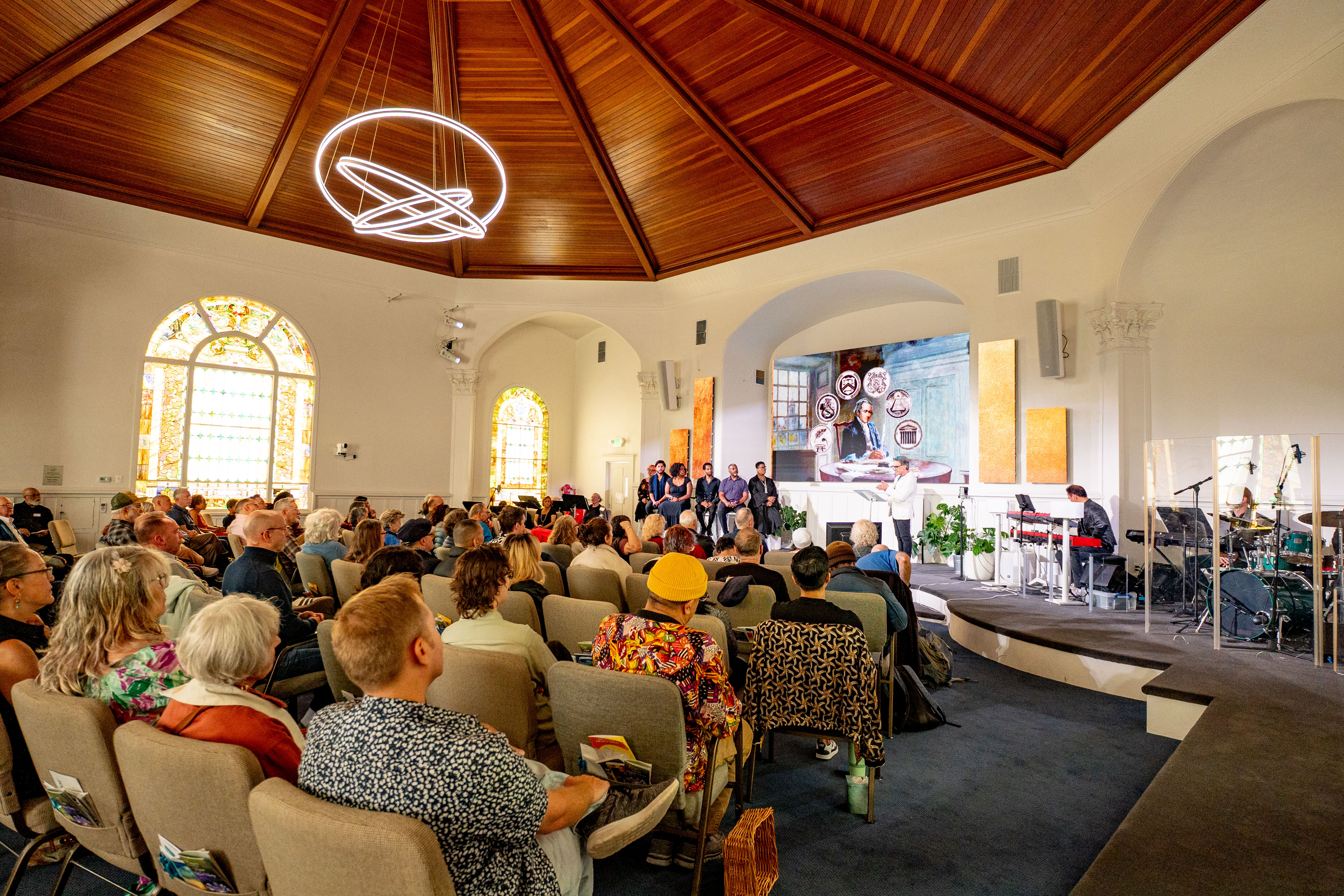 The sanctuary on Page Street with stained glass and a full congregation