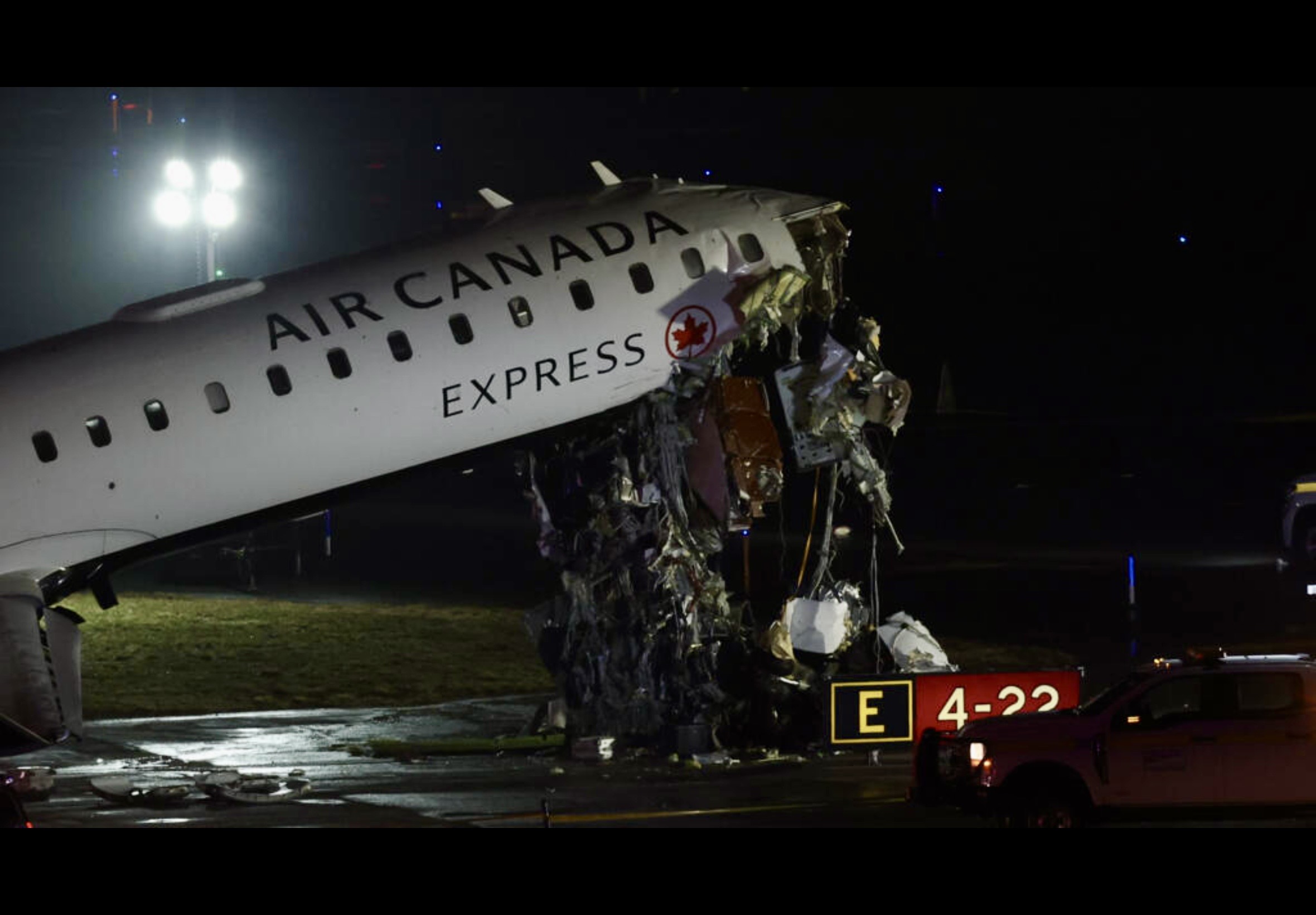 Air Canada aircraft on runway following crash at LaGuardia Airport with emergency responders present