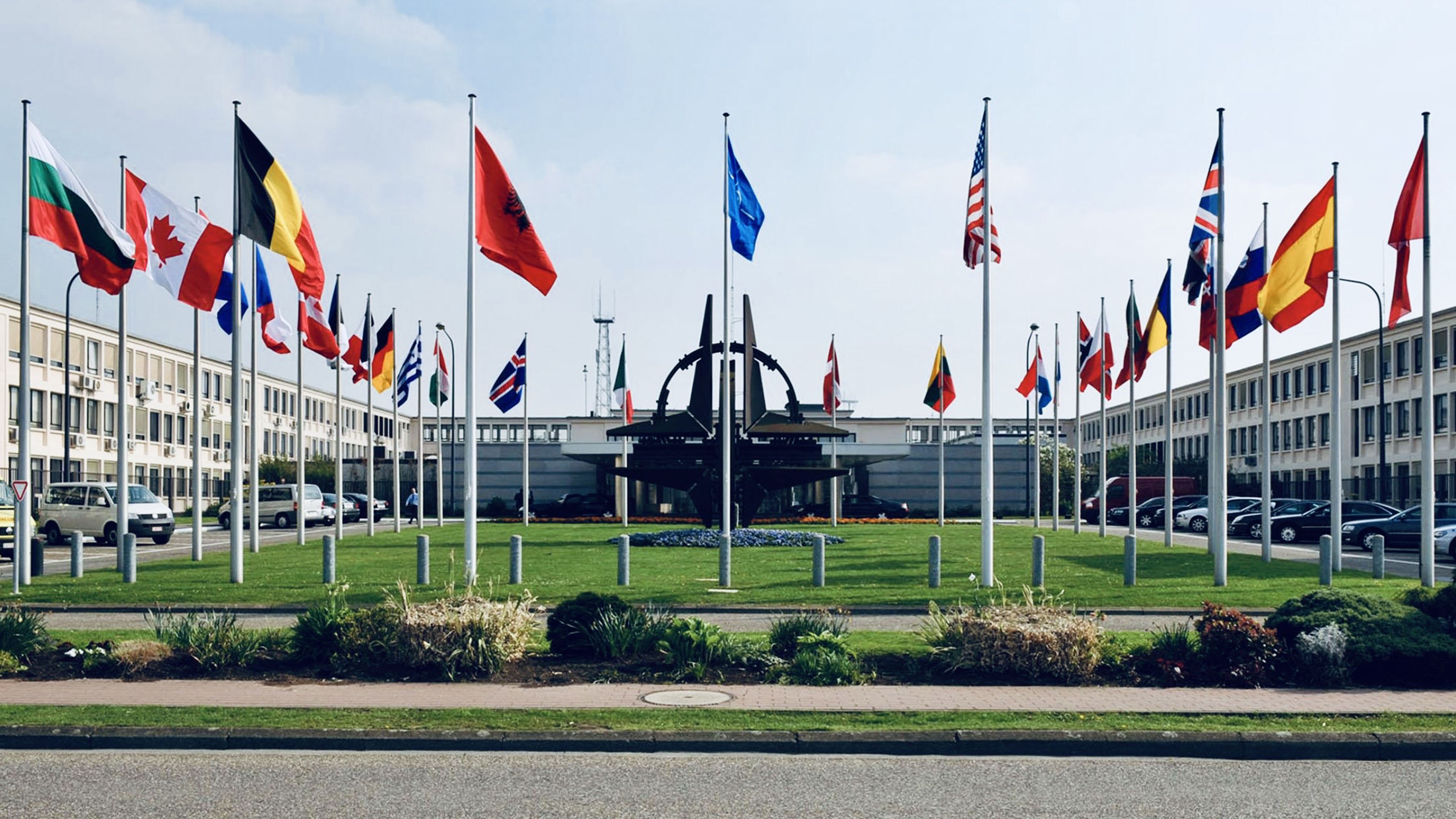 NATO headquarters with member nation flags representing the North Atlantic Treaty Organization alliance