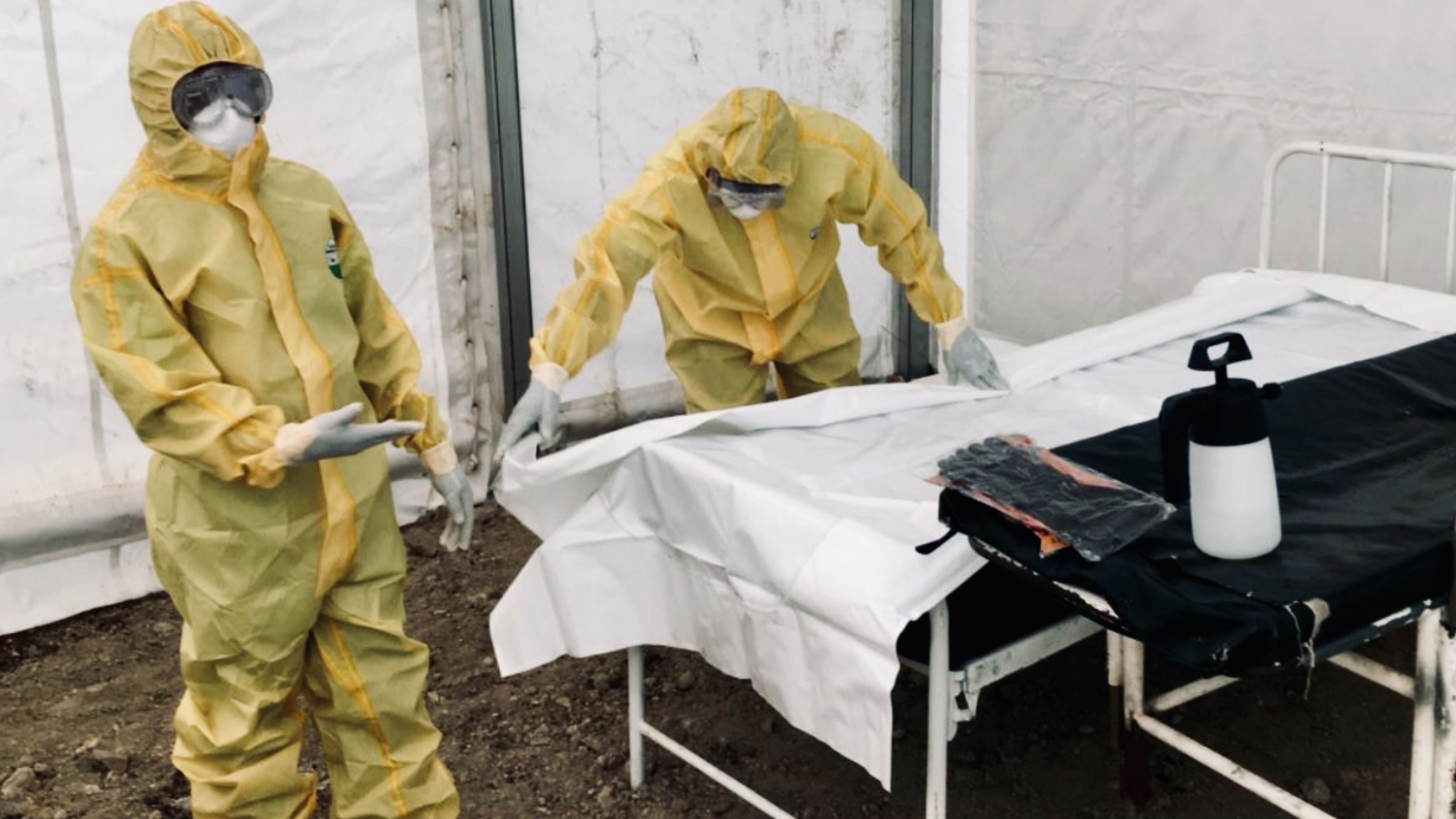 Healthcare workers wearing full protective equipment inside an Ebola treatment facility during outbreak response operations.