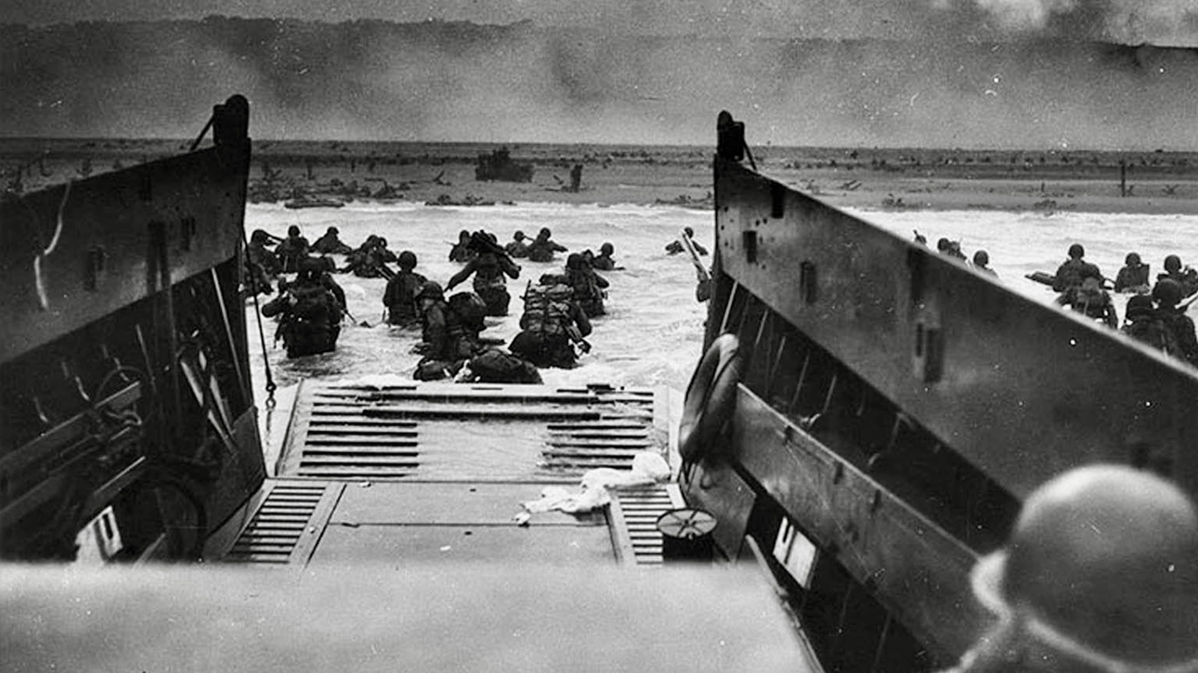 Allied soldiers wade through surf after disembarking from a landing craft during the D-Day invasion at Omaha Beach, Normandy, on June 6, 1944.