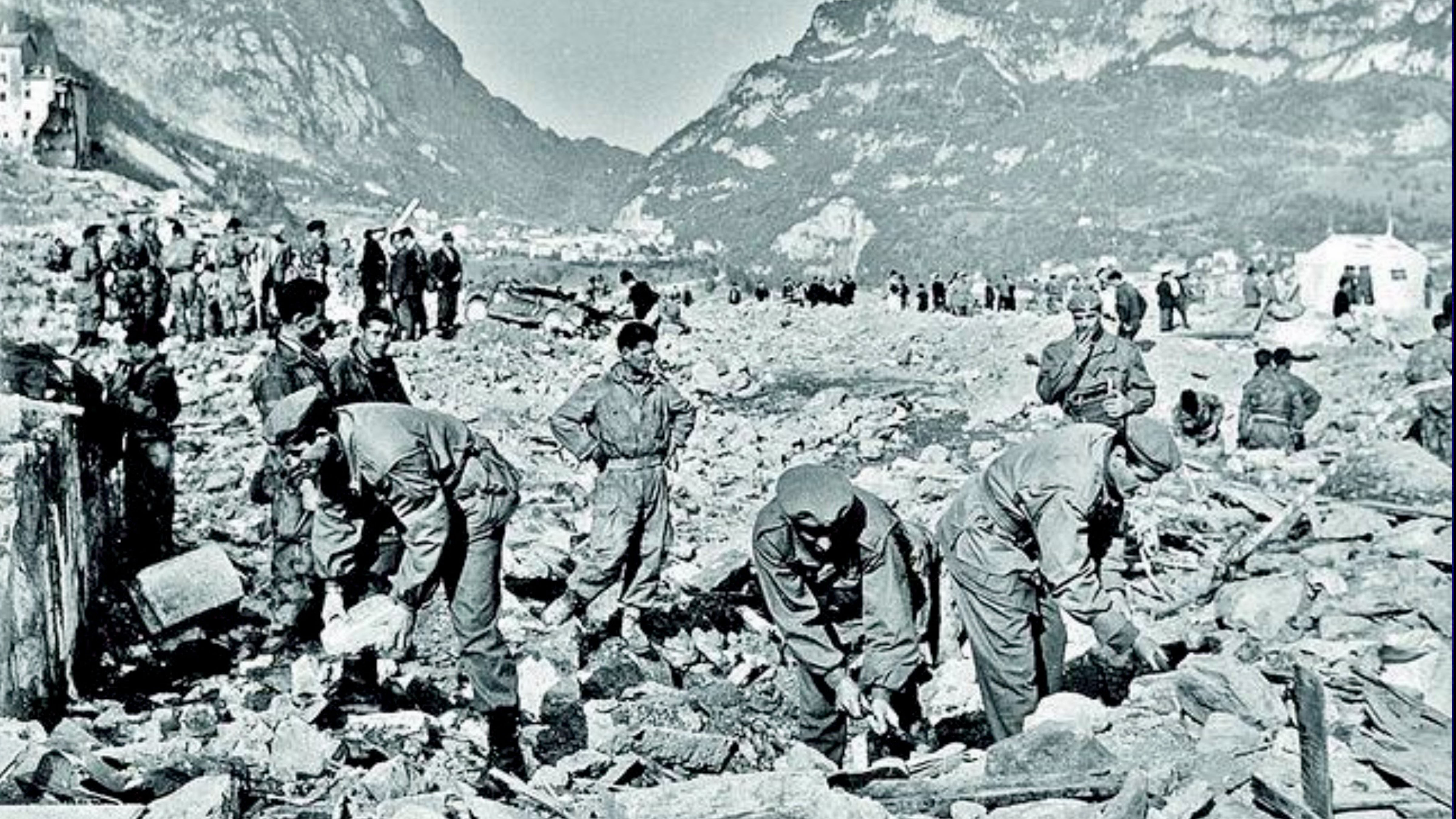 Rescue workers search through rubble and debris in Longarone, Italy, following the devastating Vajont Dam disaster of October 9, 1963.
