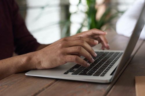 hands typing on a laptop
