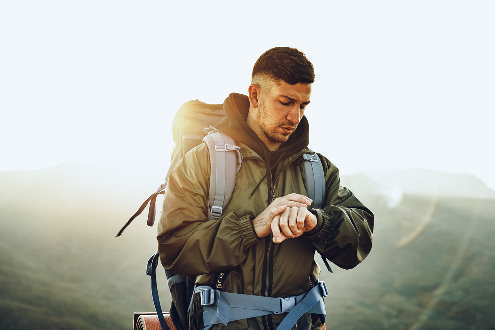 Young male traveler looking at his smart watch, close up portrait
