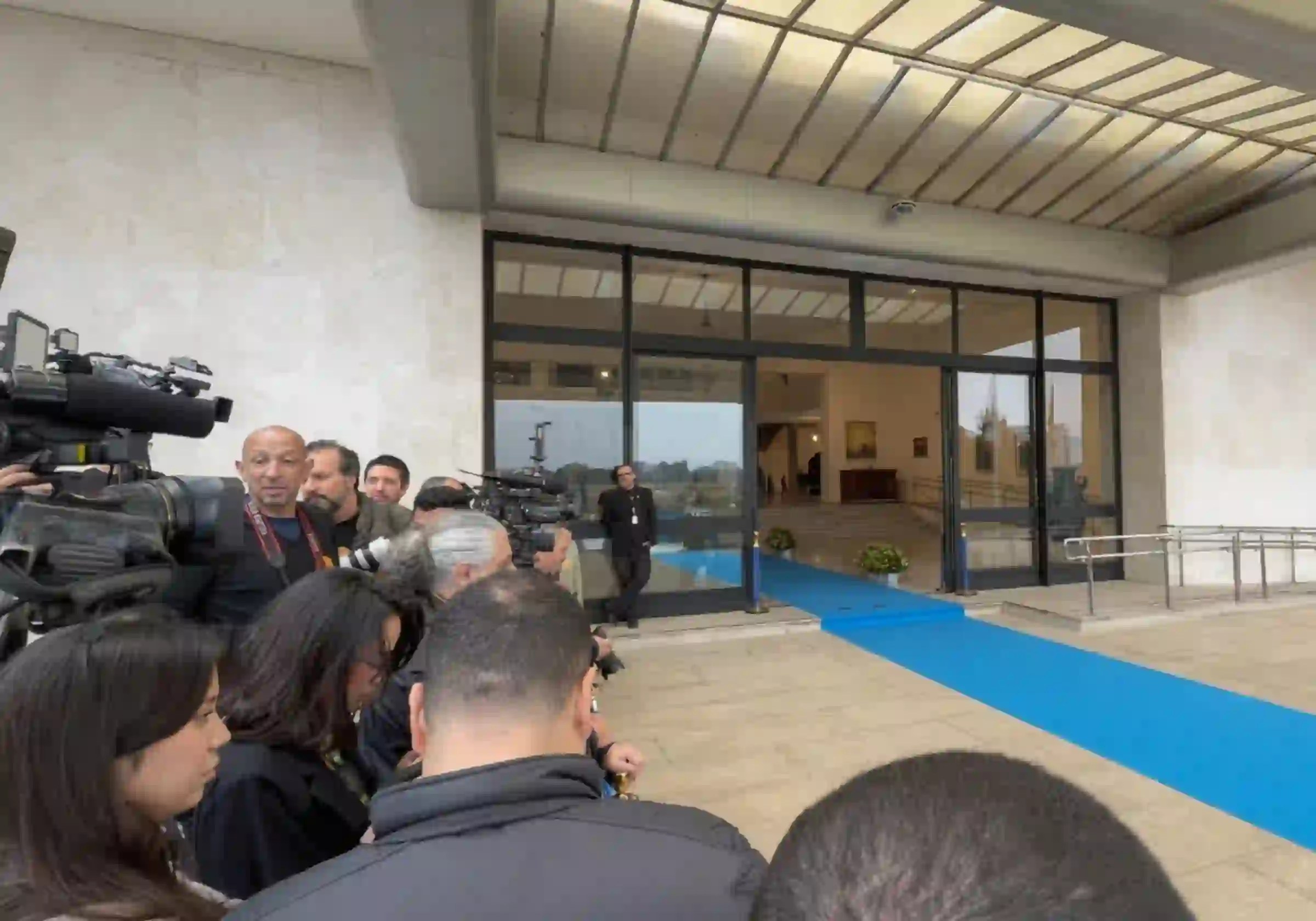 Profissionais da imprensa se posicionam ao lado do tapete azul estendido na entrada principal do Palácio dos Bandeirantes, aguardando a chegada do presidente da Argentina, Javier Milei / Imagem reprodução / Metrópoles |•| Urbs Magna
