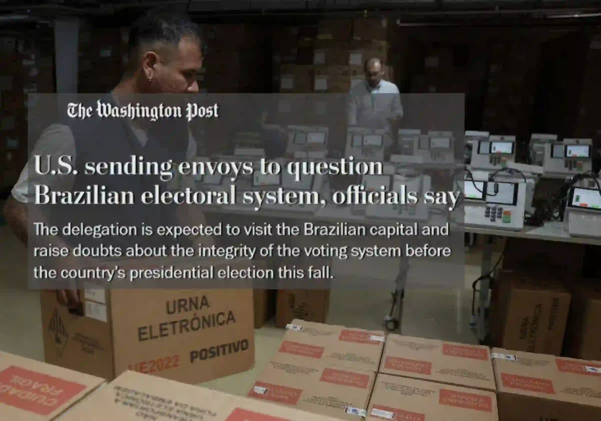 Um funcionário do Tribunal Regional Eleitoral do Amazonas organiza caixas contendo urnas eletrônicas durante os preparativos para testes em Manaus |8.7.2026| Foto: Michael Dantas/AFP/Getty Images | Manchete do jornal The Washington Post sobre o envio de autoridades dos EUA para lançar dúvidas sobre o processo eleitoral brasileiro |•| Arte Urbs Magna