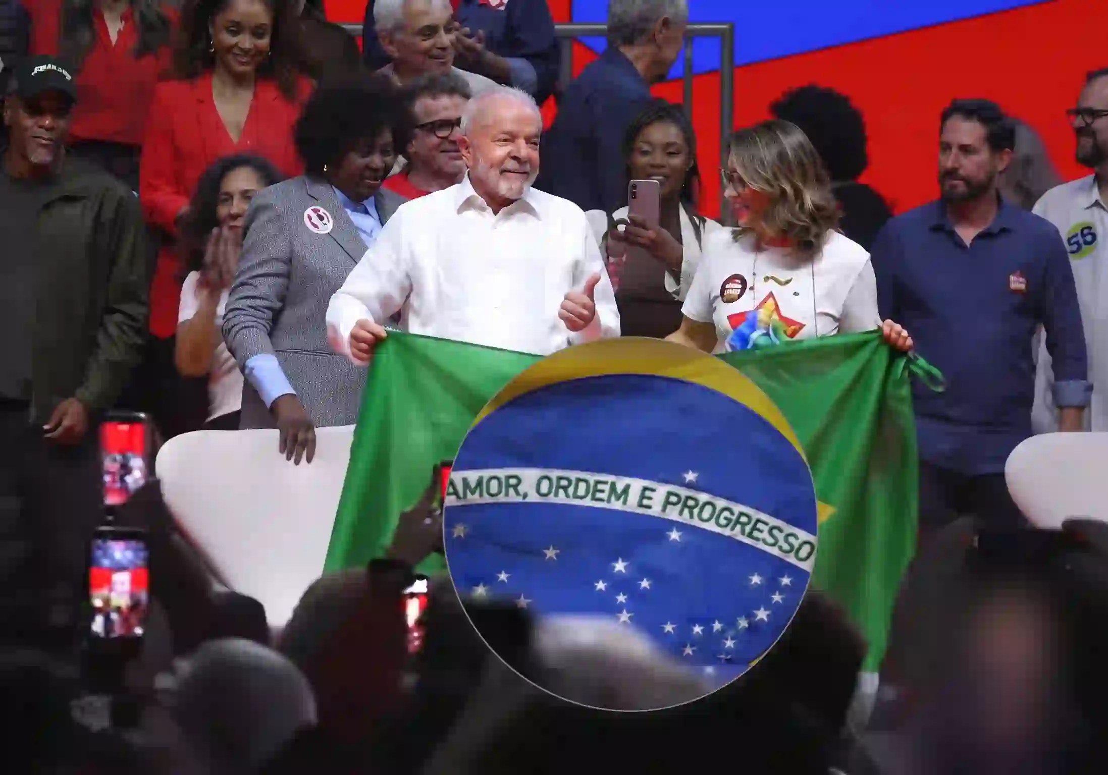 Presidente Lula e Primeira-Dama do Brasil e socióloga Rosângela Lula Silva erguem Bandeira do Brasil com faixa "AMOR, ORDEM E PROGRESSO", durante evento com artistas na Fundição Progresso, na quarta-feira (23/set) / Imagem reprodução / Lula/YouTube |•| URBS MAGNA