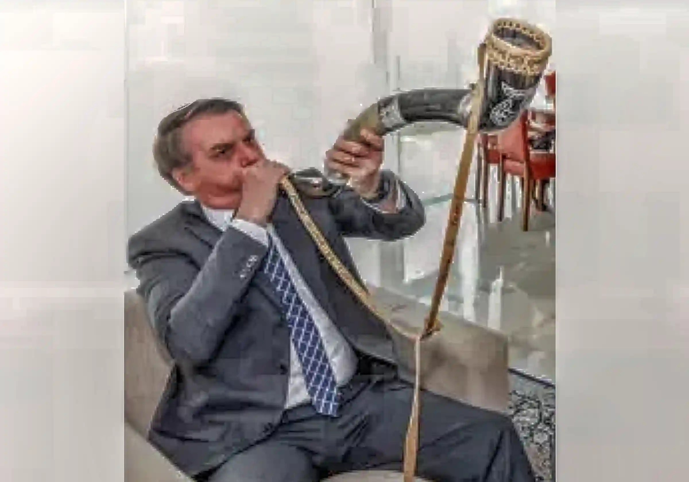O ex-presidente preso em regime domiciliar por tentativa de golpe de Estado, Jair Bolsonaro, tocando berrante / Imagem reprodução |•| Arte URBS MAGNA