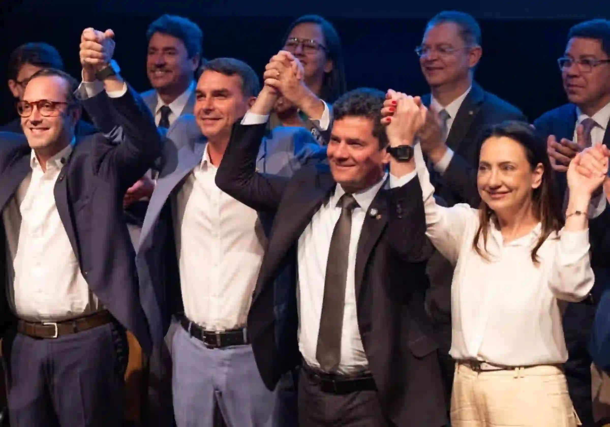Sergio Moro e Rosangela Moro, com Flávio Bolsonaro, celebram de mãos dadas a filiação do casal ao PL / Bem Paraná/Instagram |•| URBS MAGNA