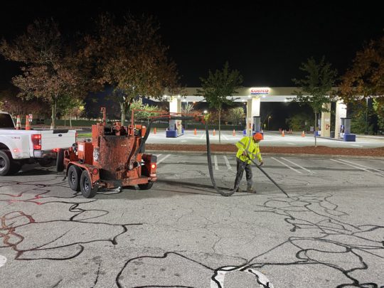7. “Hot crack filler being applied along an asphalt joint to prevent expansion and pothole formation.”