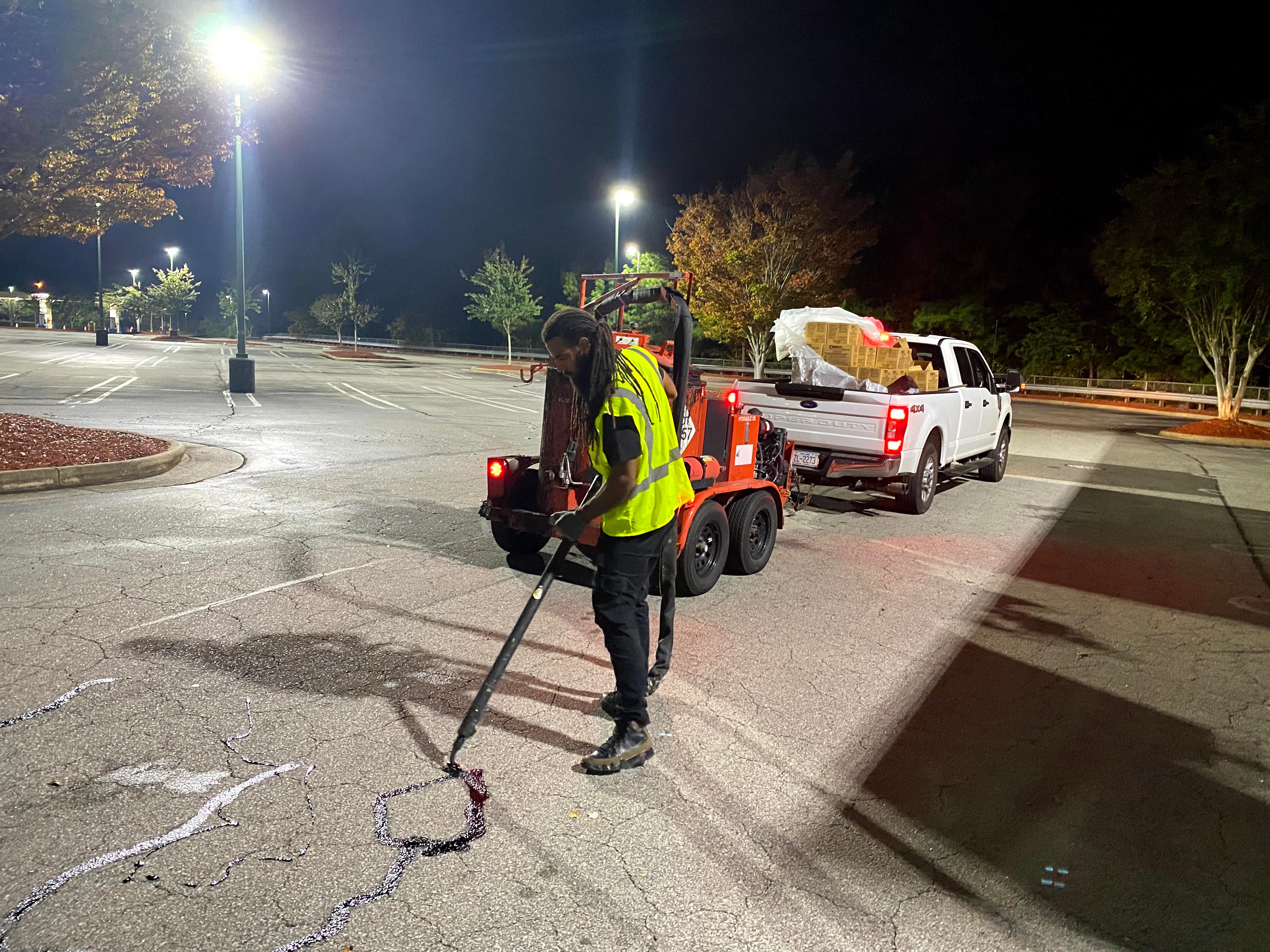 “Industrial hot crack sealing service in progress, protecting asphalt from water damage and erosion.”