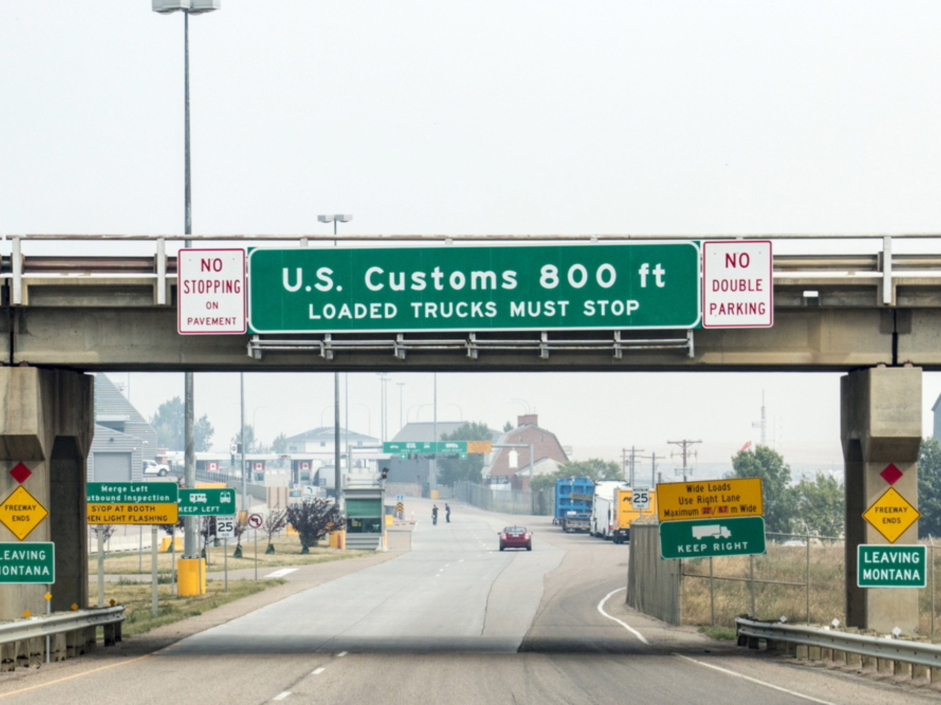 Grenzübergang zwischen den USA und Kanada mit wartenden Autos, Symbol für die Einreise an der Landgrenze