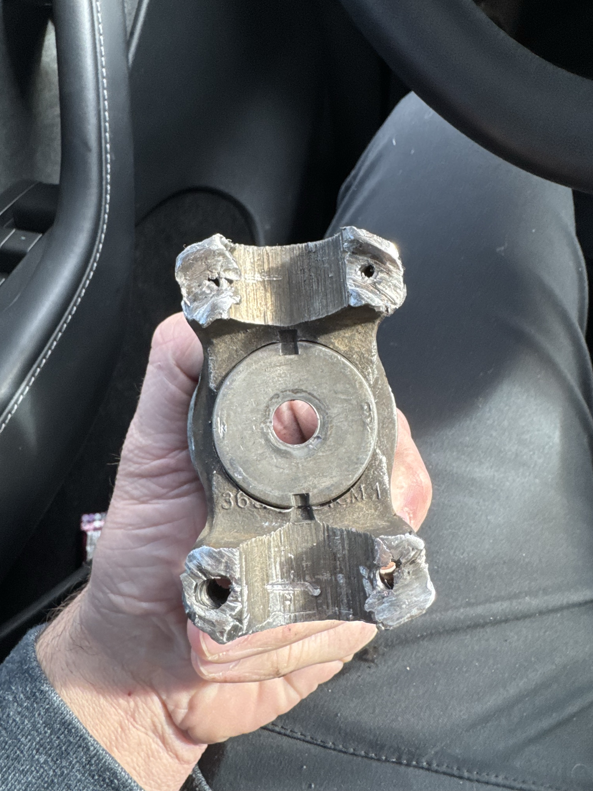 A worn universal joint yoke from a driveshaft, held in hand, as it arrived