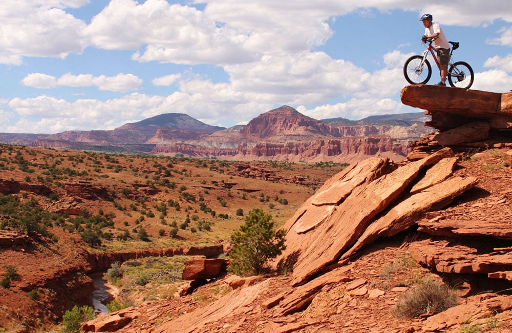 Biker standing on the edge of the mountain