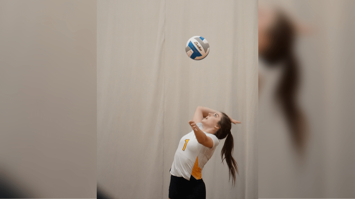 #1 Jenna Anderson makes a serve.