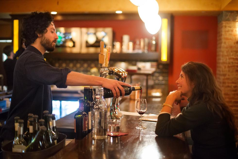 DAN LITTLE Sommelier Sébastien Piekutowski serves a glass of Artesana Tannat to Jeanne Johnson, of Adams, Thursday at ConVino wine bar in Northampton. - DAN LITTLE | DAN LITTLE