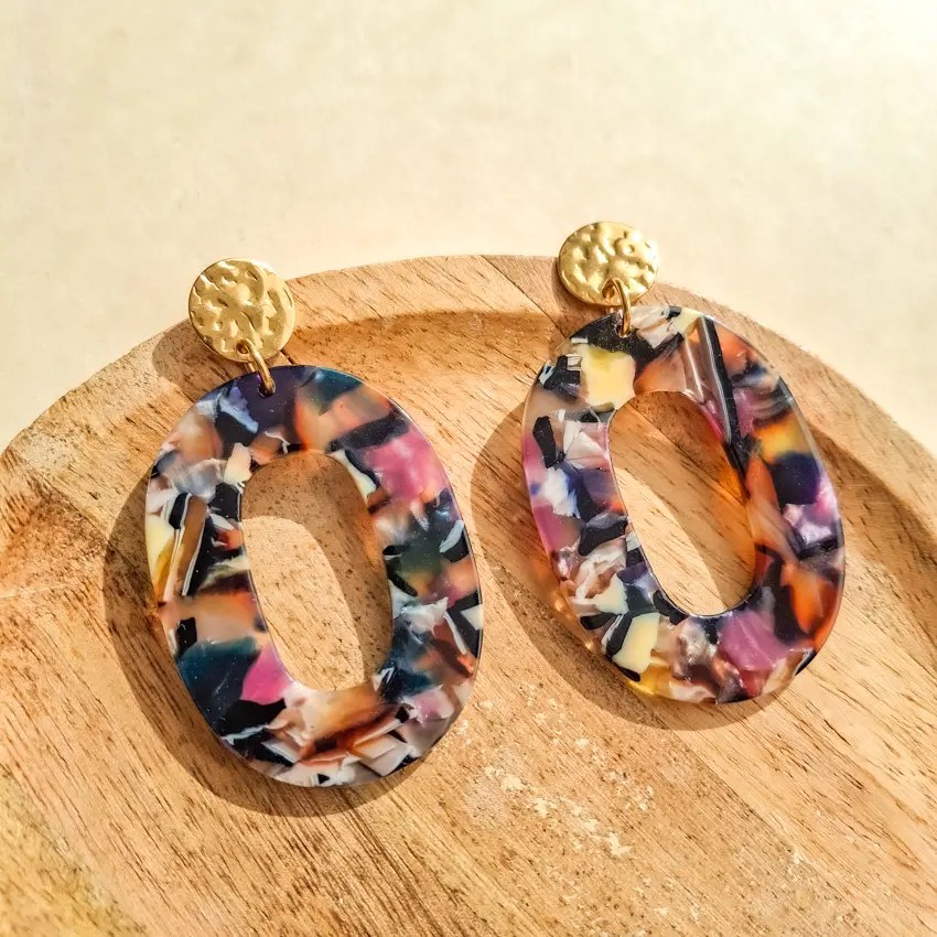 Boucles d’oreilles ovales résine multicolore effet marbré avec attache dorée texturée.