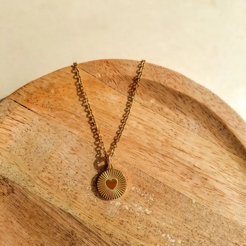 Collier cœur soleil rond en acier inoxydable doré.