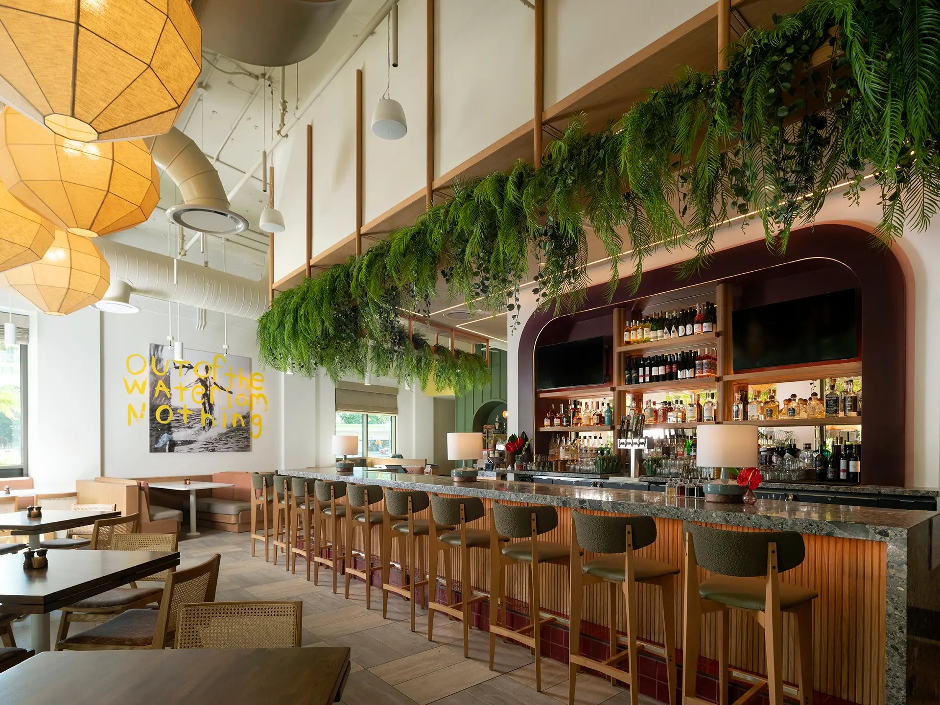 VANROOY project Favorite Son Cafe inside Hotel The Ambassador Waikiki, showing restaurant bar with globe-like lanterns and greenery hanging overhead