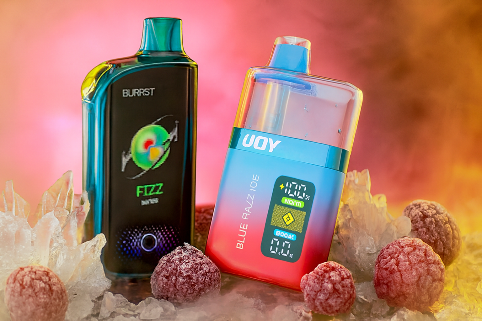 The image showcases two eye-catching vape devices nestled among ice crystals and ripe raspberries, set against a vivid pink-orange background. The left device, labeled "BURRST FIZZ DAILY VAPE," features a bold circular design, while the right one, marked "UOY BLUE RAZZ ICE," displays a digital screen showing 100% battery and "NORM" mode. The contrast between the icy elements and warm tones creates a dynamic, refreshing visual that highlights the cool, fruity essence of the products.
