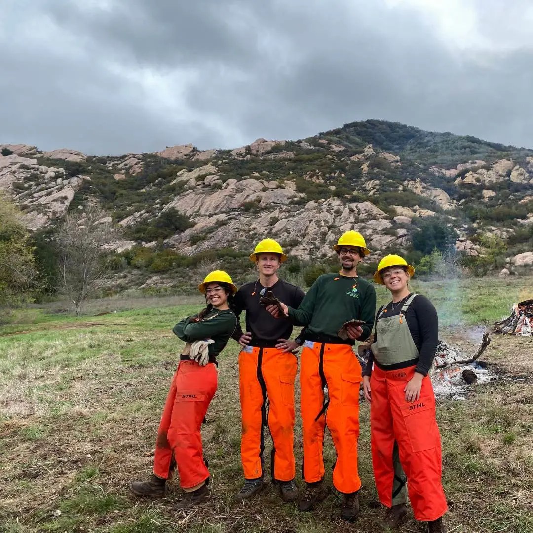 VCRCD staff posing for a picture near a burn pile