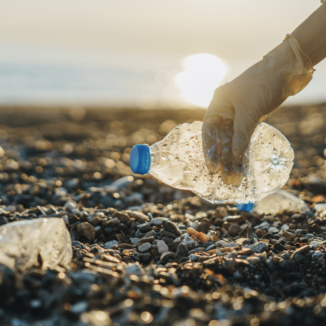 hand picking up a plastic water bottle