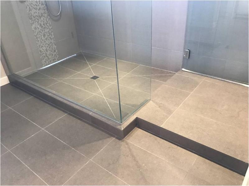 Large format floor tile with center drain — bathroom flooring installation by VCV Services