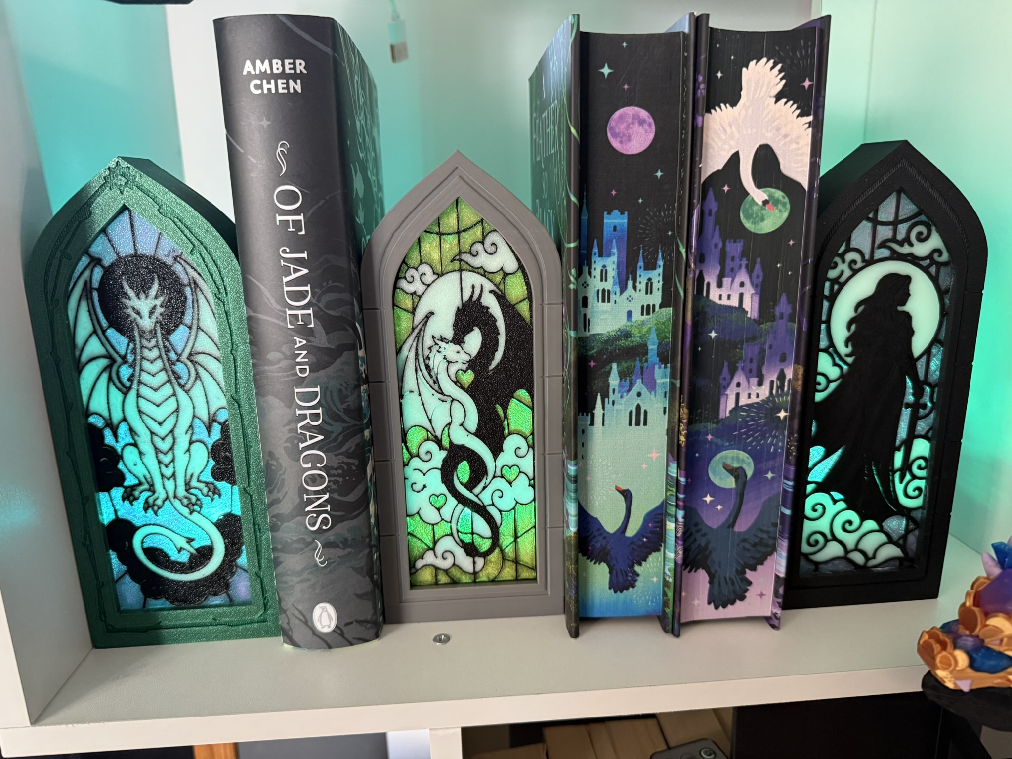 Illuminated gothic arched book nooks arranged beside a row of books