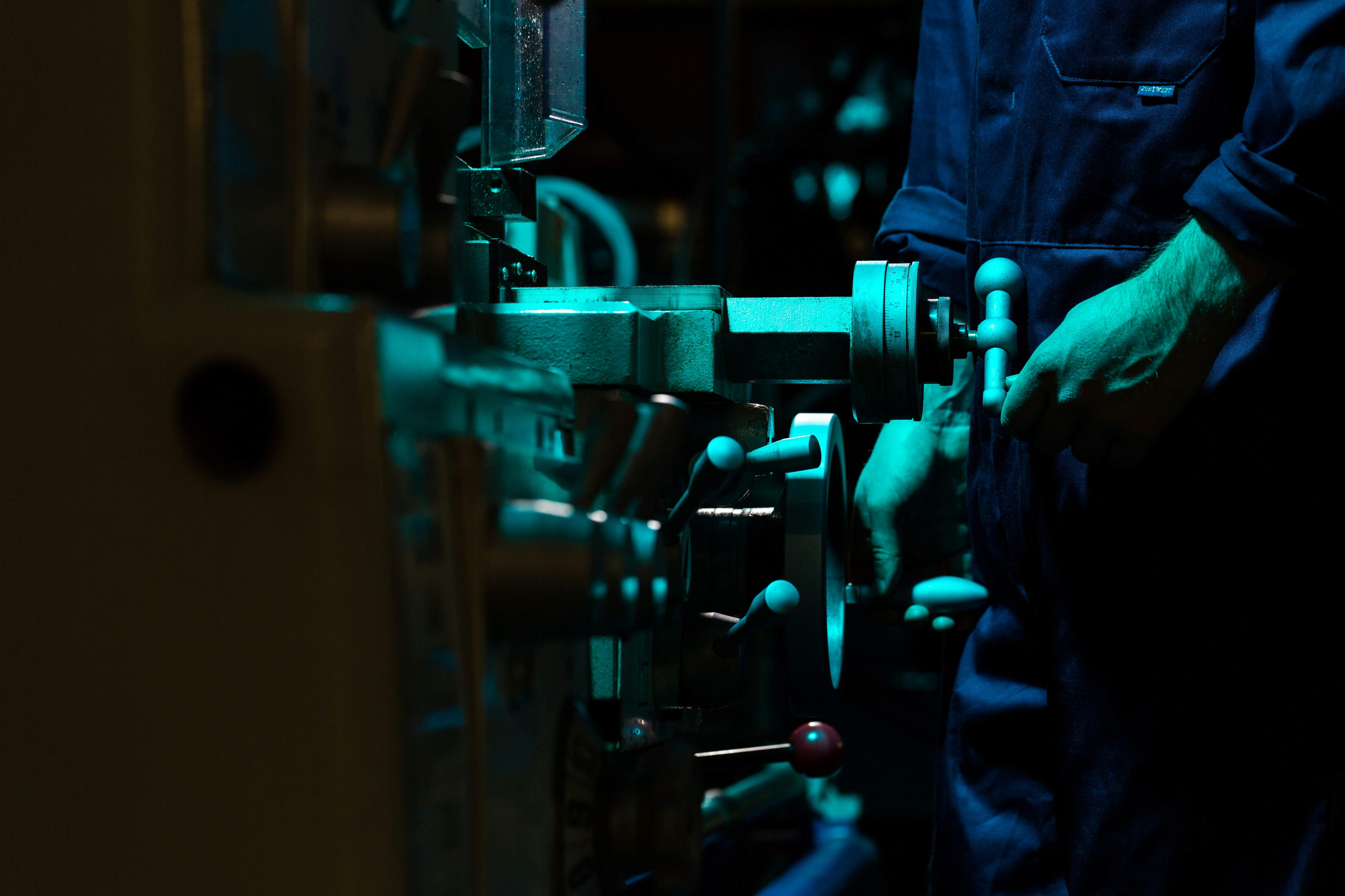 Technician operating and setting up industrial machinery inside a production facility during machine installation and startup process.