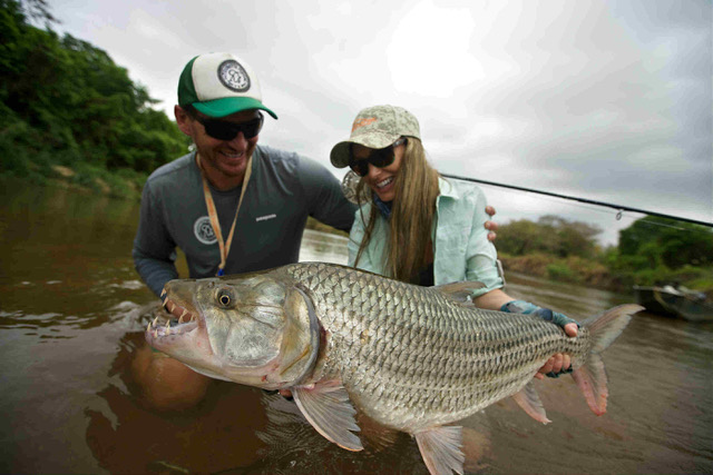 photo of Rebekka Anderson Redd and a guide holding a tigerfish