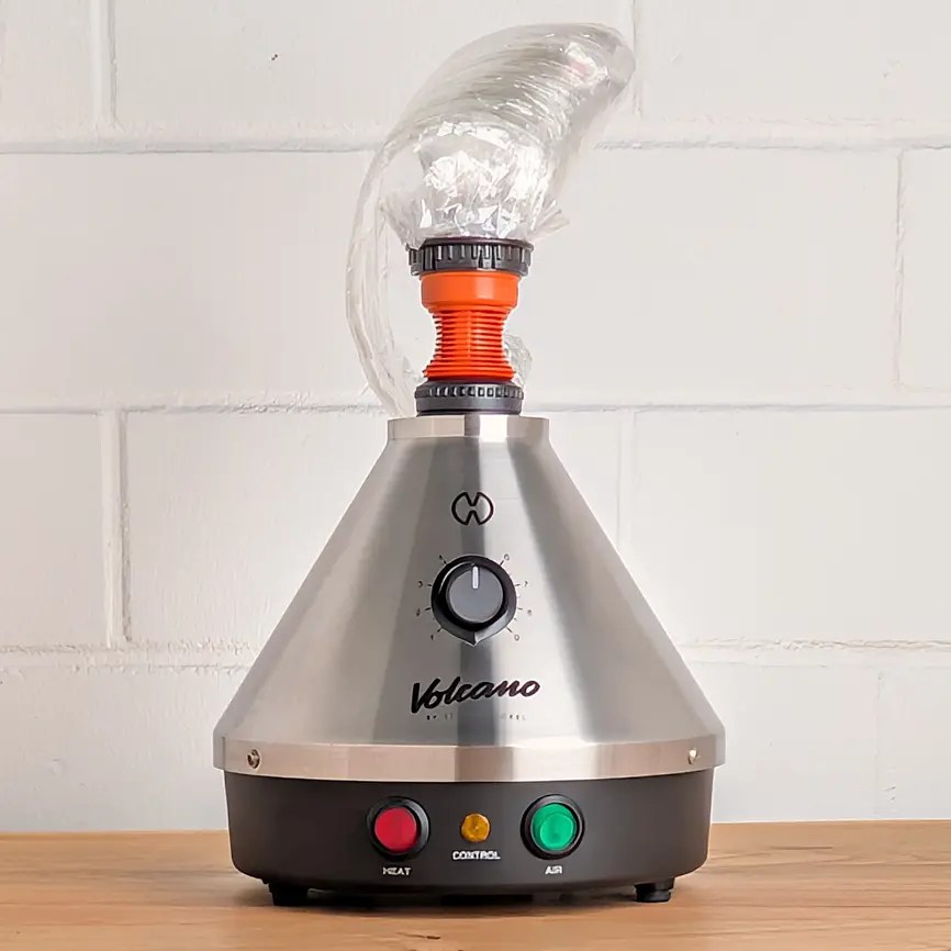 Ein Vocano Classic Vaporizer mit aufgesetztem Ballon steht auf einem Holztisch.