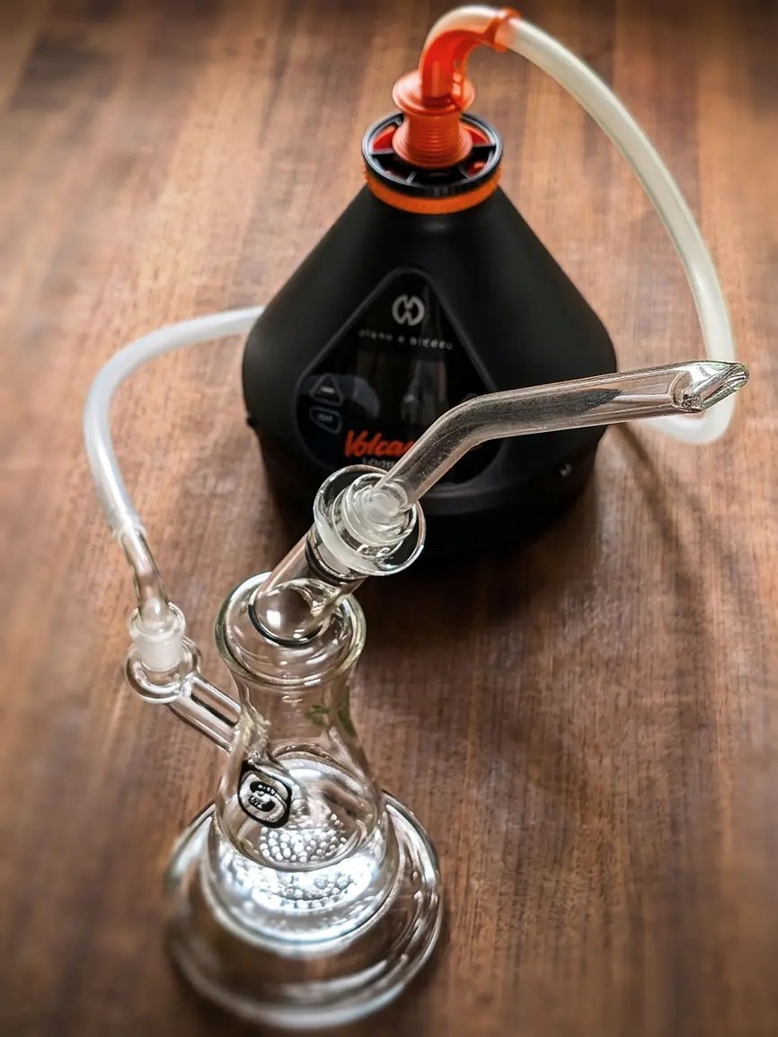 Volcano Hybrid Vaporizer im Hintergrund, angeschlossen an den Chugga Jug 2.0 Bubbler über einen Whip-Schlauch mit EHLE Mundstück.