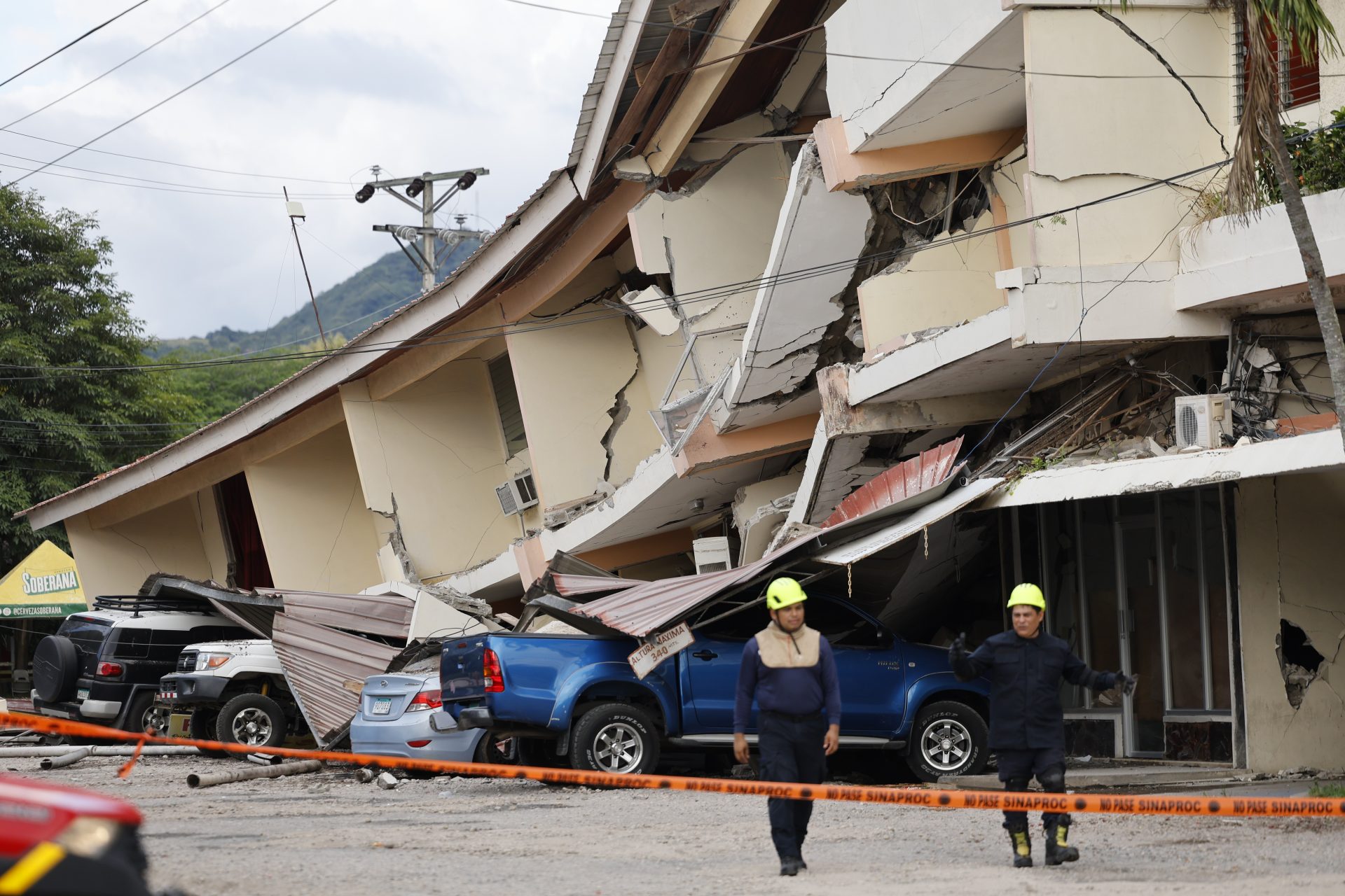 Socorristas caminan frente a una edificación afectada por el terremoto de magnitud 7,7 que sacudió el sureste de Panamá, con una profundidad de 10 kilómetros y generó daños en varios edificios y carreteras cercanas a la localidad de Tonosí, epicentro del temblor, este viernes en Penonomé (Panamá). EFE/ Bienvenido Velasco